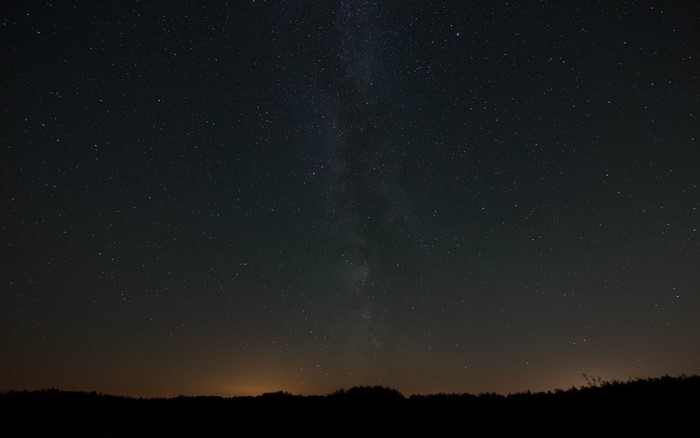 Night sky with Milky Way over silhouetted landscape