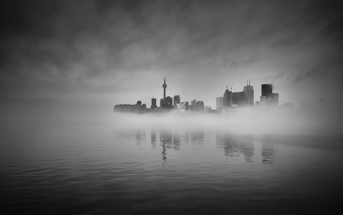 Toronto skyline shrouded in fog over water