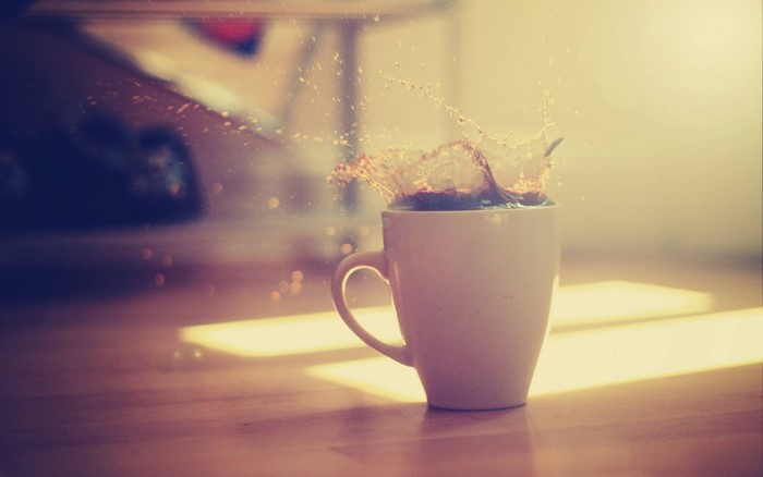 Coffee splash in a white mug with light