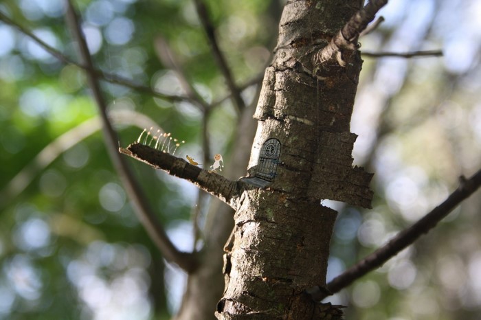 Fairy door and tiny figures on a tree branch