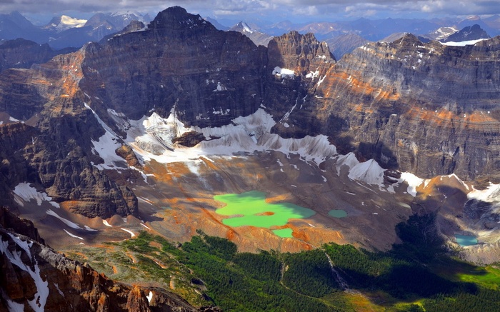 Turquoise lakes in a mountain valley with snow and trees