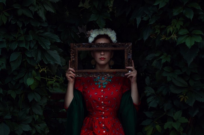 Woman in red dress holding a picture frame