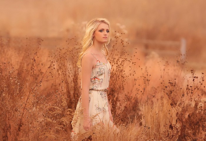 Woman in a dress standing in a dry field