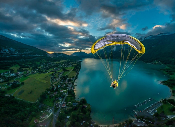 Paraglider over a lake at sunset with mountains