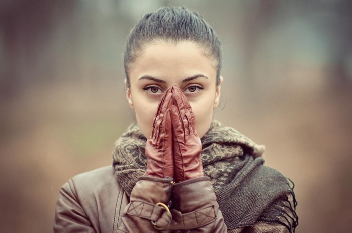 Woman wearing gloves and scarf, praying
