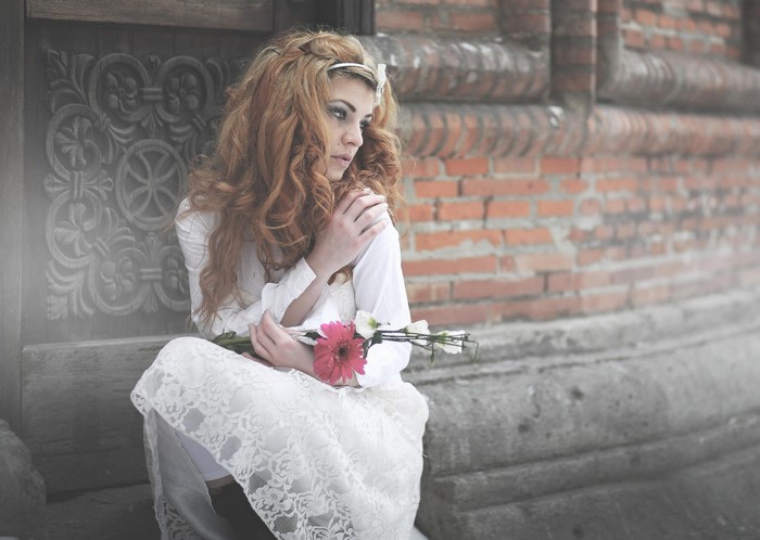 Woman in white dress holding flowers