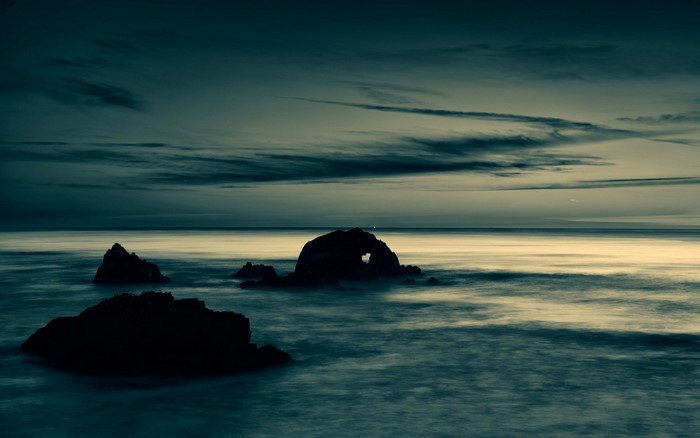 Sea rocks at dusk with archway
