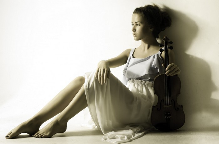 Woman in dress sitting with violin