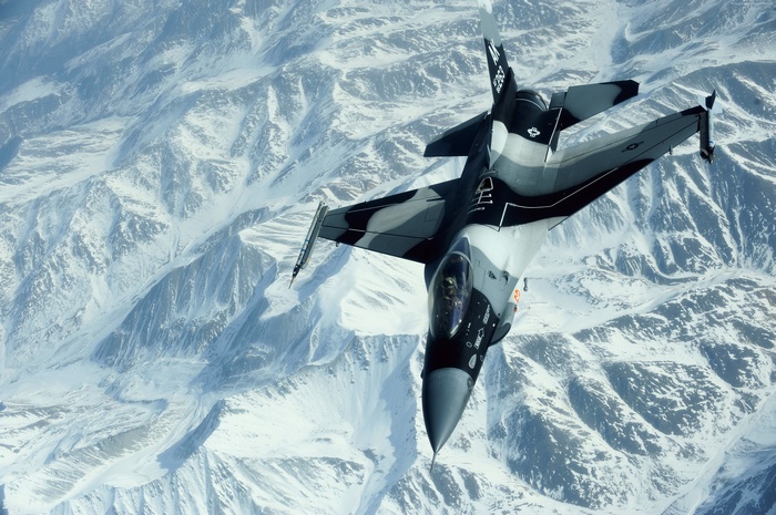 F-16 Fighting Falcon over snow-covered mountains
