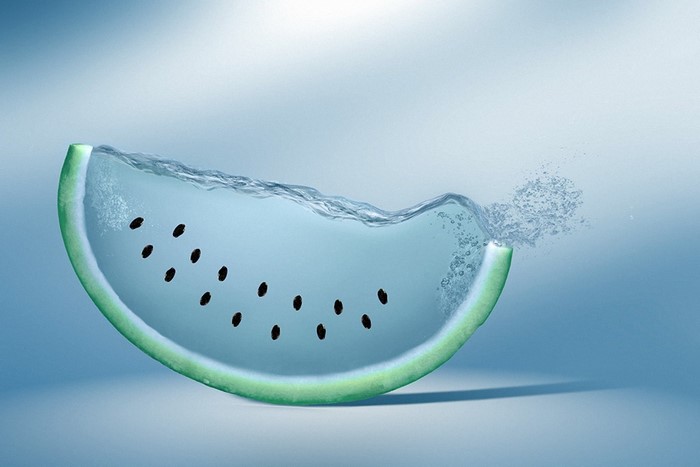 Slice of watermelon filled with water and splashing