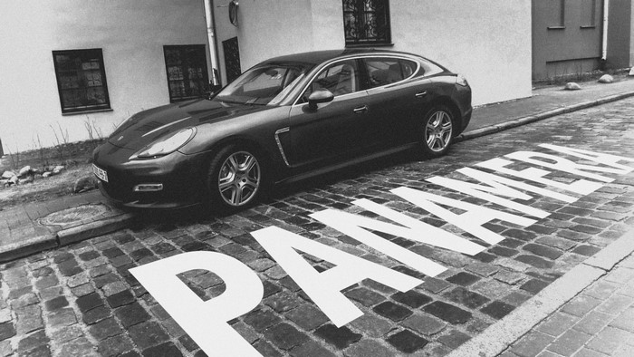 Porsche Panamera parked on cobblestone street with text