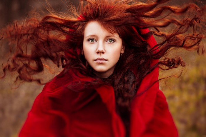Ann Nevreva with flowing red hair and red cloak
