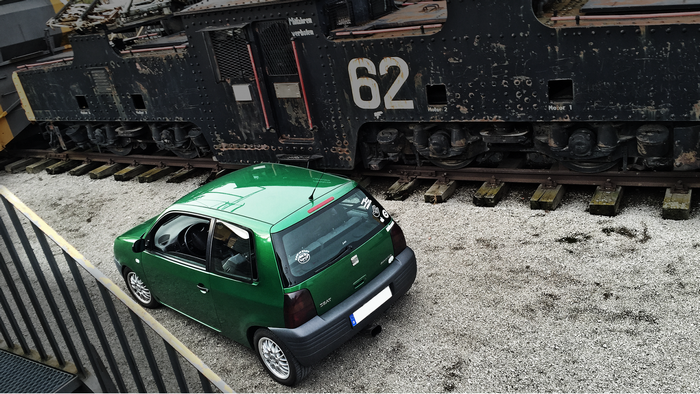 Green Seat Arosa parked next to a vintage train