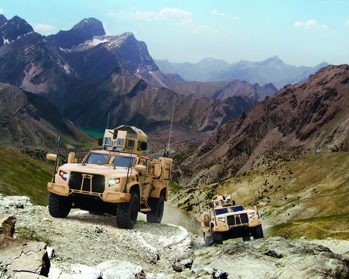 Two Lockheed Martin JLTVs driving on a mountain road
