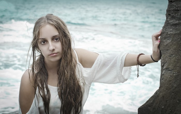 Young woman with wet hair by the ocean