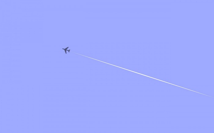 Minimalist airplane flying with contrail against blue sky