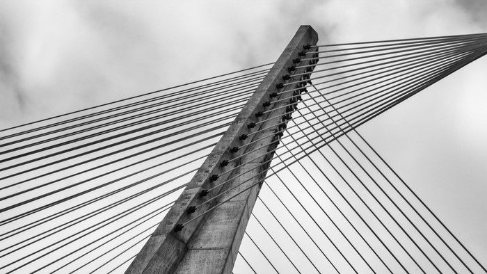 Monochrome photograph of a cable-stayed bridge mast and cables