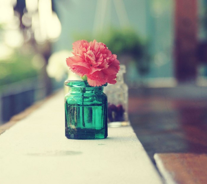 Pink flower in a green glass jar