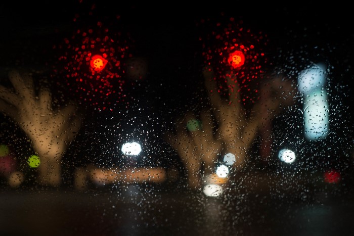 Rainy night with blurred traffic lights and trees