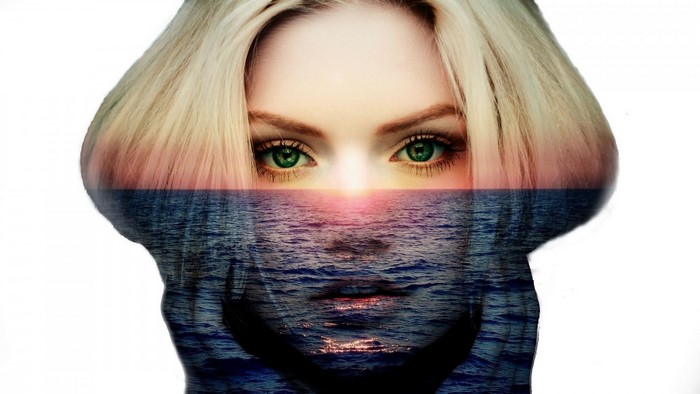 Double exposure of woman's face and sunset over the sea