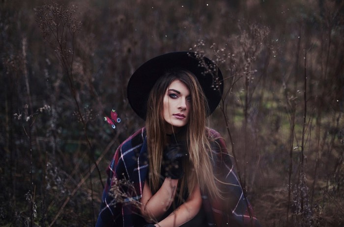 Woman in hat and plaid blanket with butterfly