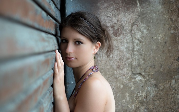 Woman leaning against a textured wall