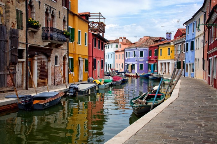 Colorful buildings line a canal with boats in Venice
