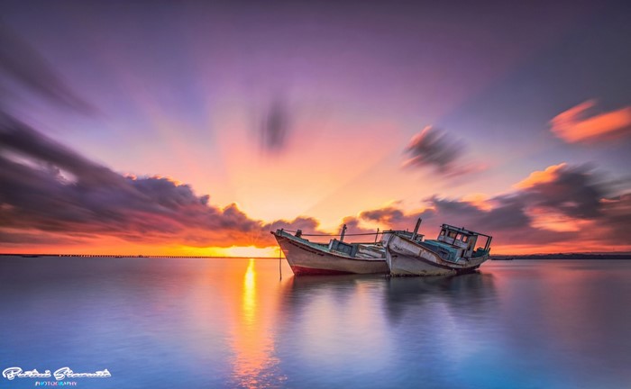 Two boats on the sea at sunset with colorful sky