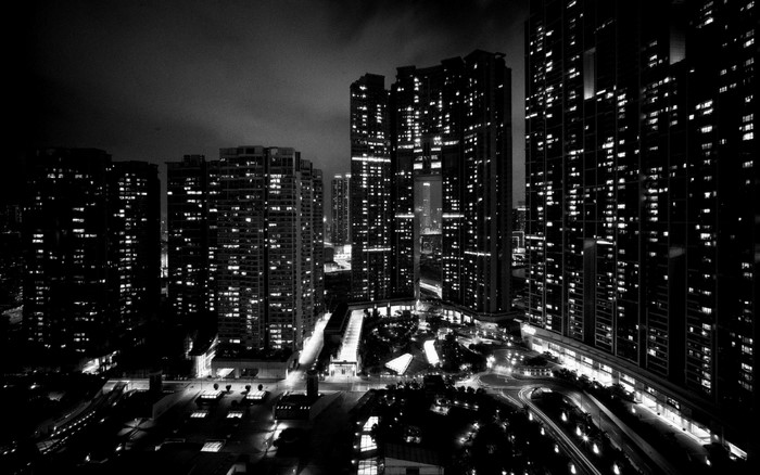 Monochrome cityscape at night with illuminated skyscrapers