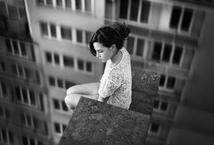 Woman in white dress sitting on rooftop
