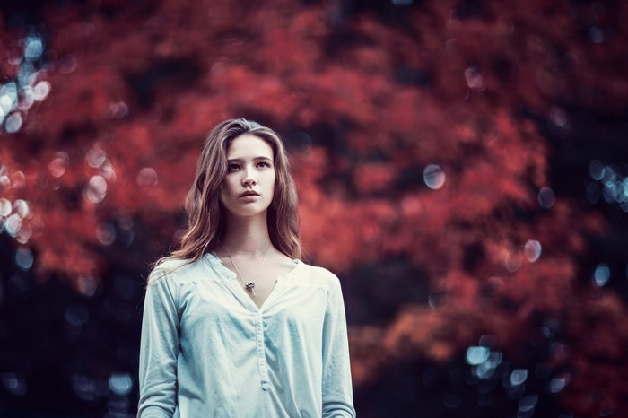 Woman with long brown hair wearing a white shirt