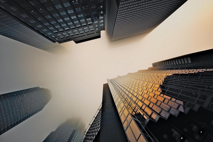 Skyscrapers shrouded in mist, viewed from below