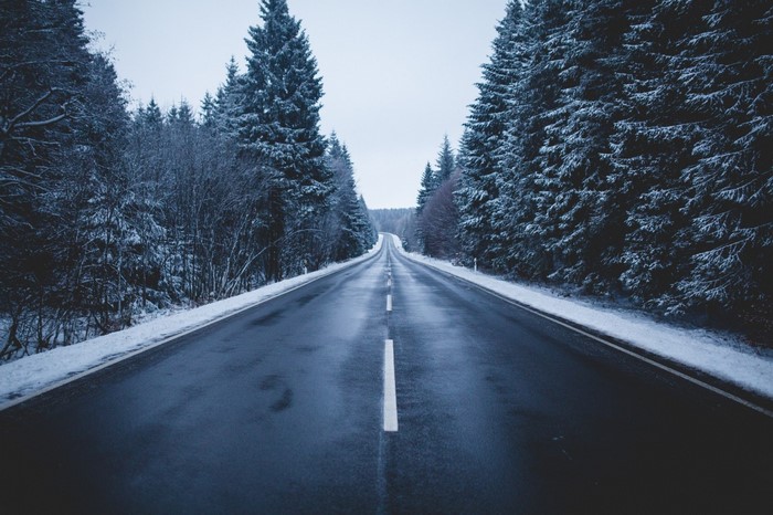 Winter road through a snow-covered forest