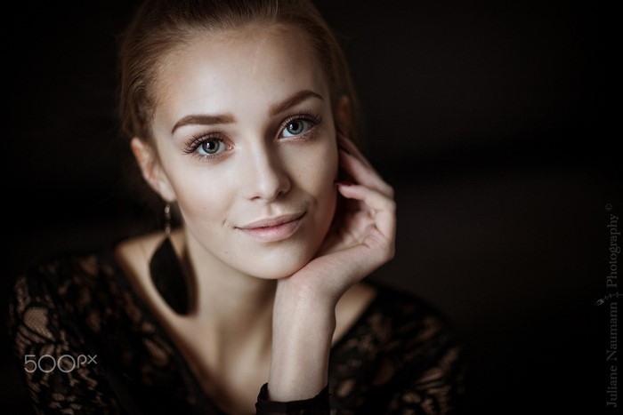 Portrait of a young woman with blue eyes and dark lace top