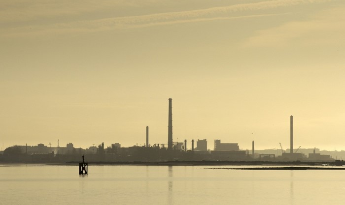 Industrial skyline across water at dawn