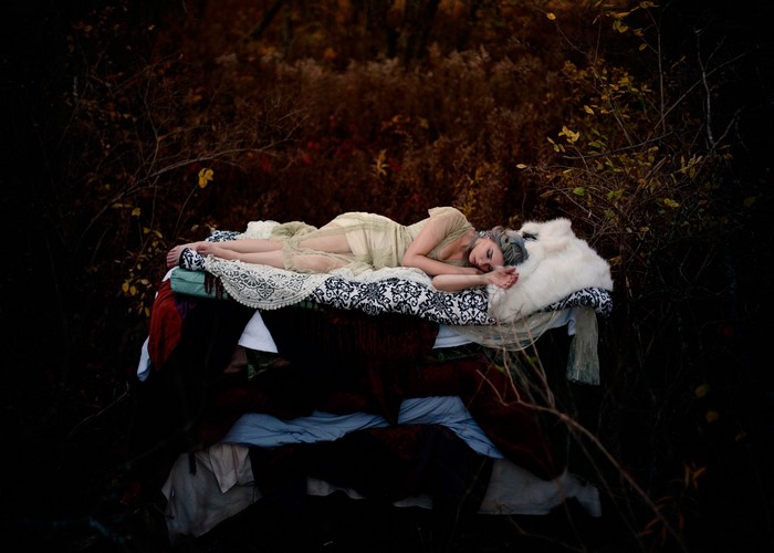 Woman sleeping on a bed in a dark forest