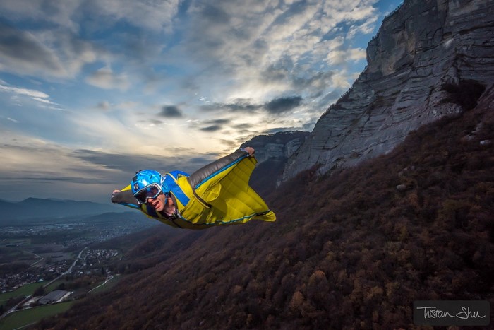 Wingsuit flyer near a cliff face