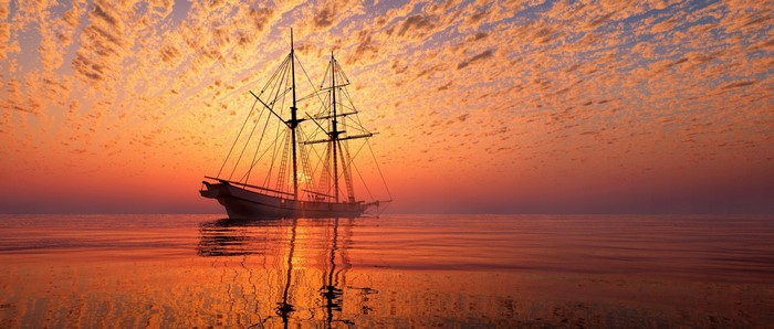 Sailing ship on the sea at sunset