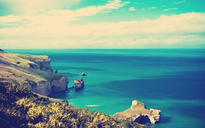 Coastal cliffs overlooking a turquoise sea with rock formations