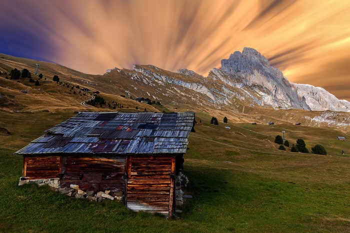 Wooden hut in the Alps with dramatic clouds