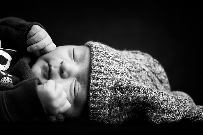 Monochrome portrait of a sleeping baby in a knitted hat
