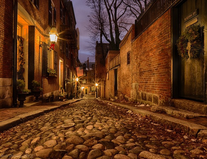 Cobblestone street in a historic city at night