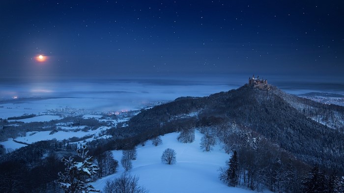 Winter night landscape with castle and moon