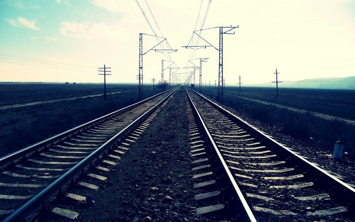 Railway tracks stretching into the distance with overhead power lines