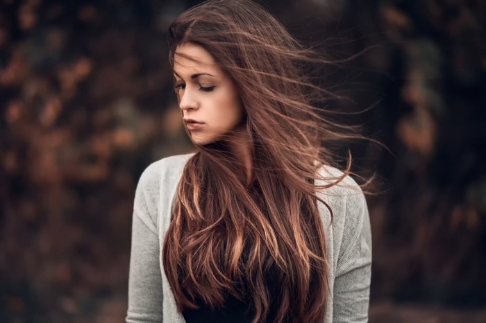 Woman with long auburn hair in a grey cardigan