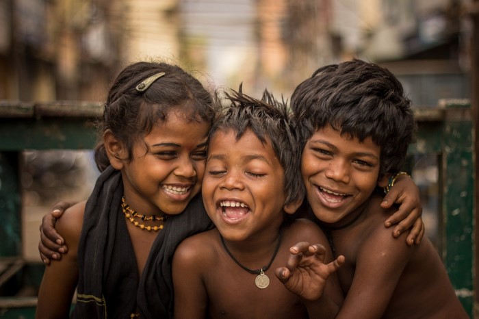 Three happy children embracing and laughing