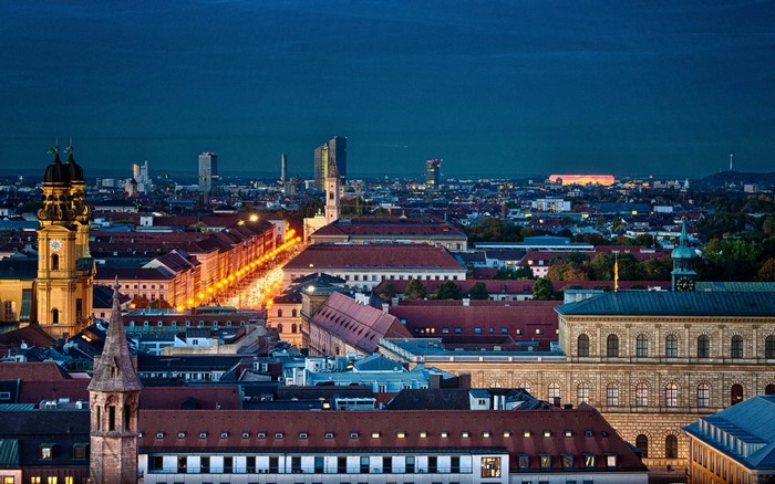 Munich cityscape at dusk with illuminated buildings and skyline