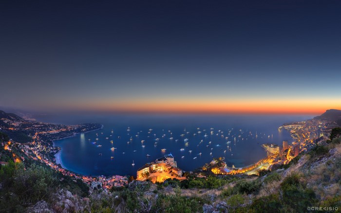 Panoramic view of Monaco coastline at dusk with yachts