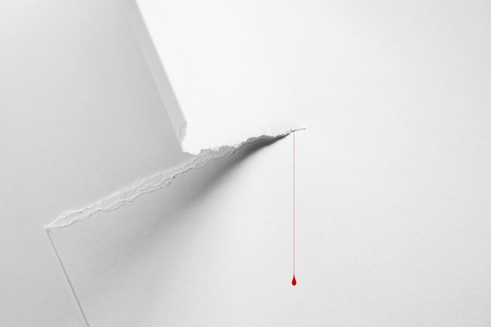Torn paper with a drop of blood