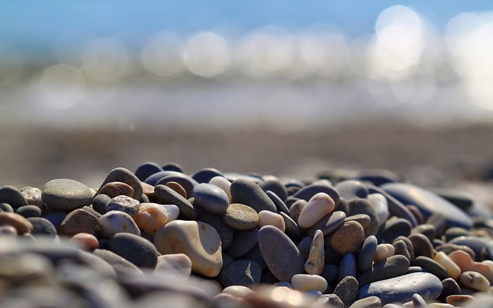 Close up of pebbles on a beach with the sea in the background